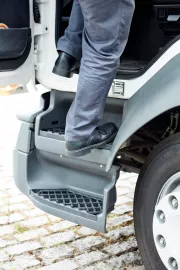 A driver coming out of the cabin, using anti slippery steps